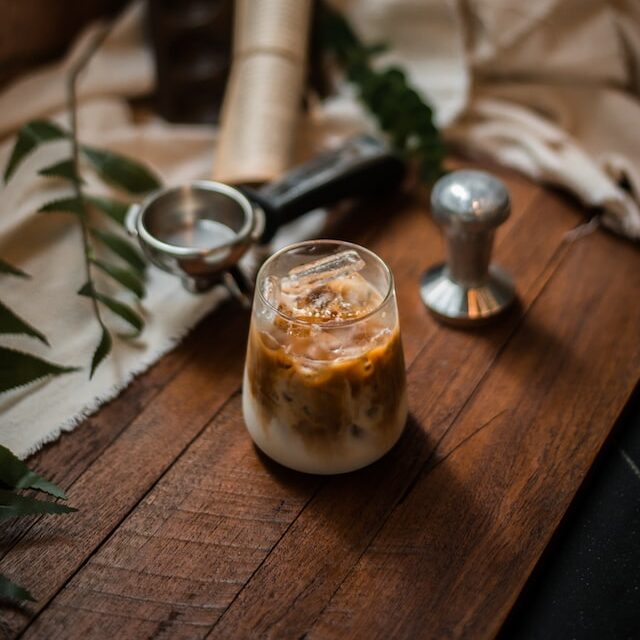 ice vanilla latte on wooden table with coffee gear