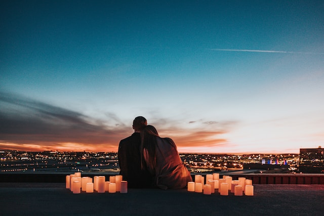 a couple looking at sunset surrounded by romantic candles