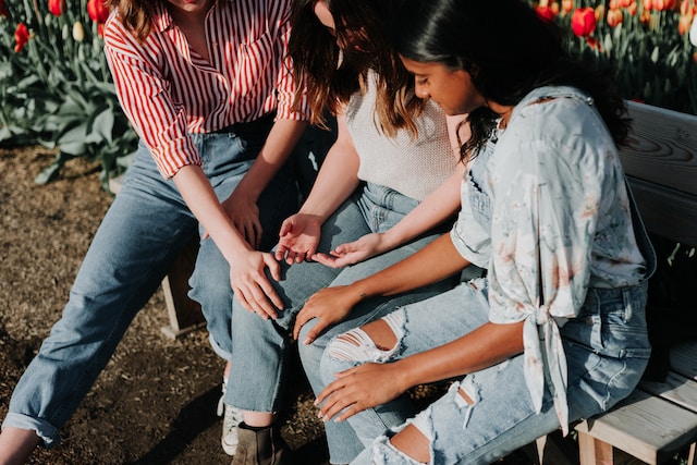 three girls friends comforting and supporting each other