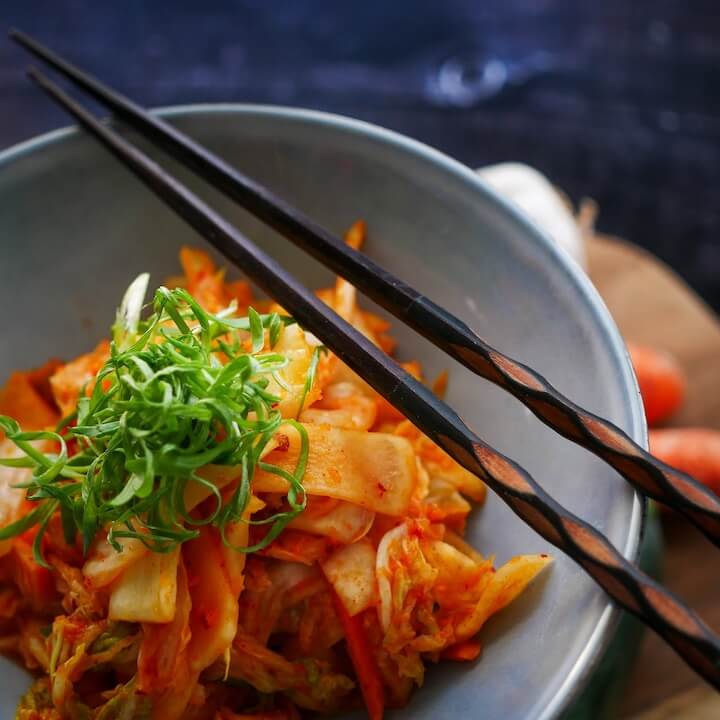 wooden-chopsticks-on-top-of-a-bowl-with-korean-food-kimchi